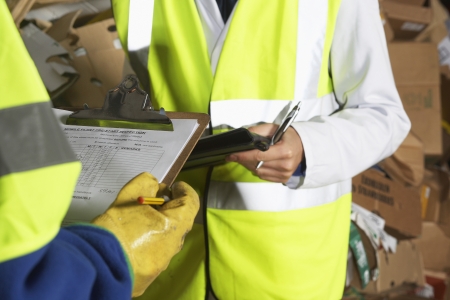 Two factory workers holding clipboards mid sectionの写真素材