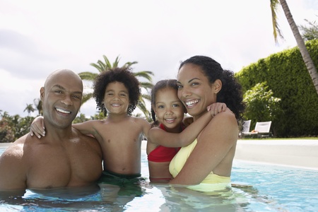 Parents with son and daughter (5-6 years) in pool portraitの写真素材