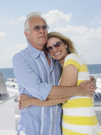 Middle-aged couple embracing on yacht portraitの写真素材