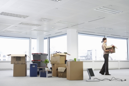 Businesswoman in Office with Moving Suppliesの写真素材