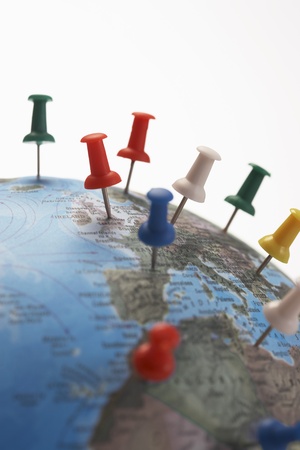 Push pins in various parts of globe studio shot close upの写真素材