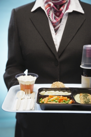 Stewardess holding tray with airplane food mid sectionの写真素材