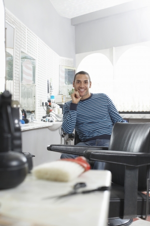 Man sitting in barbers shop smiling portraitの写真素材