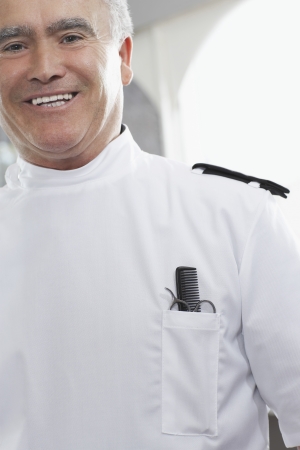 Barber with comb and scissors in pocket portraitの写真素材