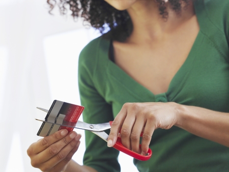 Woman cutting credit card low angle view mid sectionの写真素材