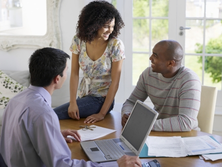 Couple sitting at dining table with financial advisor elevated viewの写真素材