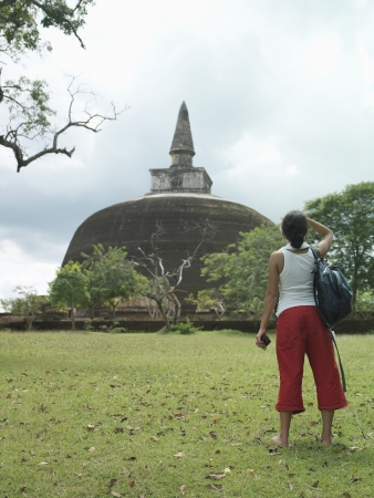 Young woman looking at stupa back viewの写真素材