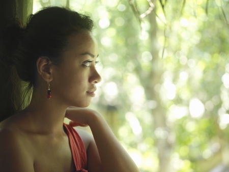 Portrait of young woman looking at trees profileの写真素材