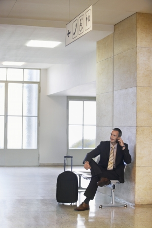Business man using mobile phone in airportの写真素材