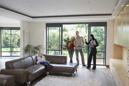 Parents with bored daughter (7-9) and estate agent observing new propertyの写真素材