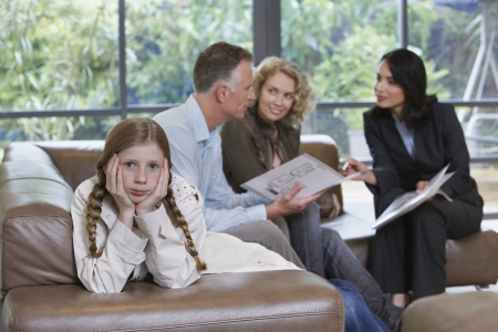 Parents with bored daughter (7-9) and estate agent discussing new propertyの写真素材