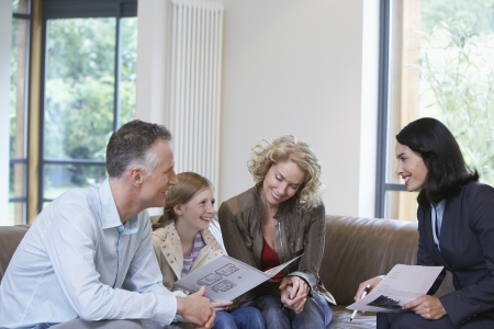 Parents and daughter (7-9) with estate agent discussing new propertyの写真素材