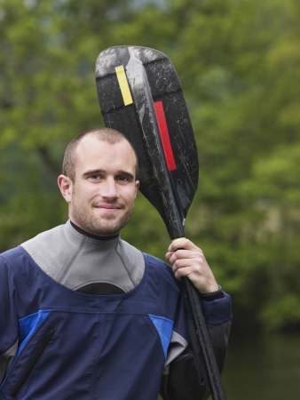 Man with kayak paddle outdoors portraitの写真素材