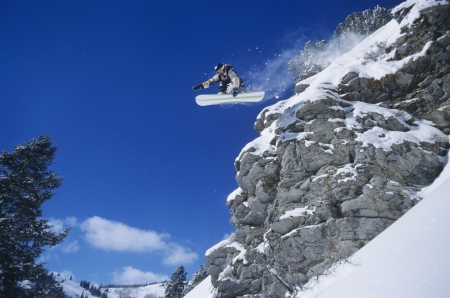 Person on snowboard jumping low angle viewの写真素材