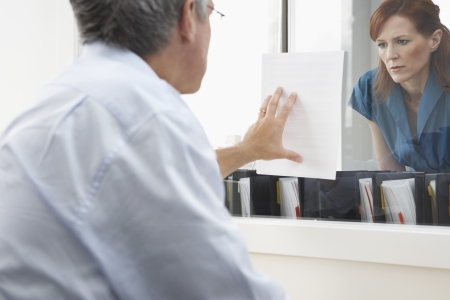 Man showing woman paper in officeの写真素材