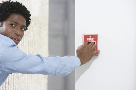 Man starting fire alarm indoorsの写真素材