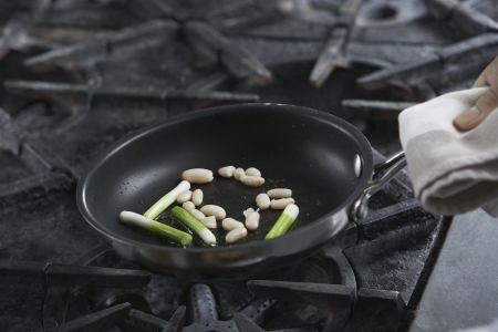 Chef cooking food in frying pan close-upの写真素材
