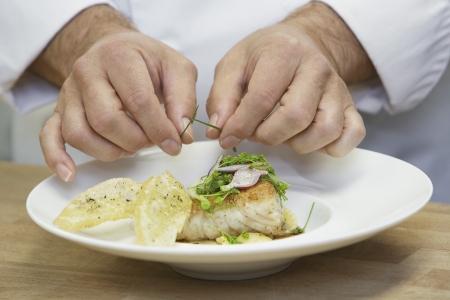 Male chef garnishing food close-upの写真素材