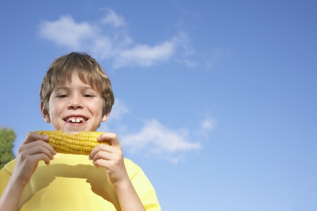 Portrait of boy (7-9) eating corn on the cobの写真素材