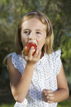 Portrait of girl (5-6) eating appleの写真素材