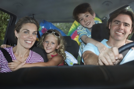 Family with two children (5-6) in car interior portraitの写真素材