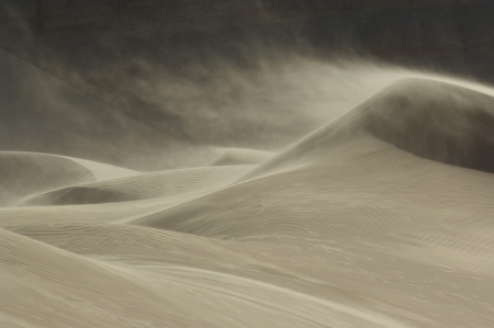 Sand blowing over sand dune in windの写真素材