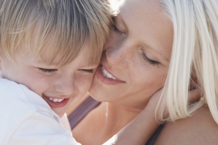 Young mother kissing son (3-4) close-upの写真素材