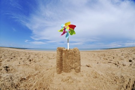 Sand castle with pinwheel on beachの写真素材