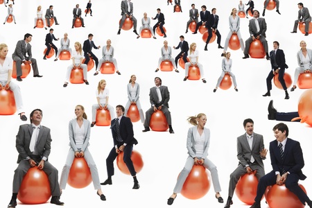 Large group of business people bouncing on inflatable balls studio shotの写真素材