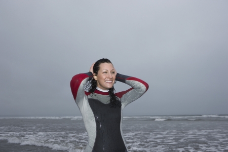 Female surfer standing on beach portraitの写真素材