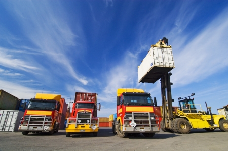 Lift truck loading shipping containers onto trucksの写真素材