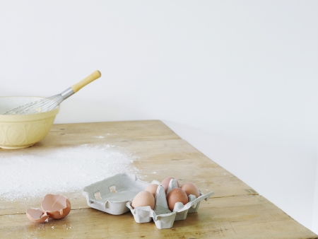 Bowl eggs and flour scattered on table