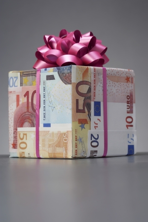 Small gift wrapped in Euro notes with bowの写真素材