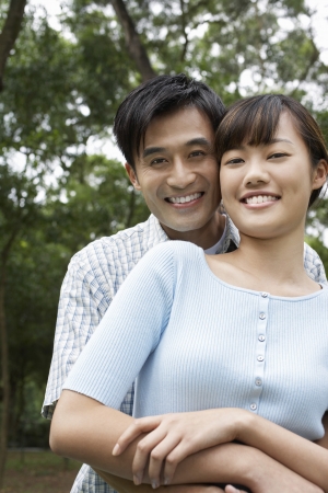 Mid adult couple embracing in park portraitの写真素材