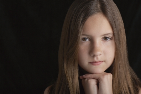 Girl (10-12) on black background portraitの写真素材