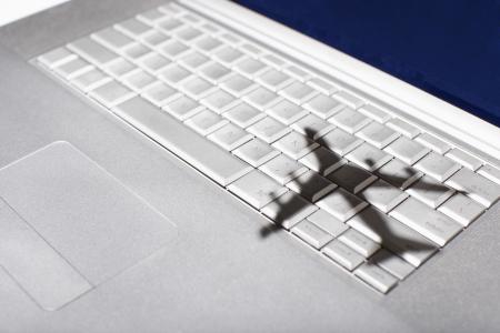 Shadow of jumbo jet over apple macintosh keyboardの写真素材