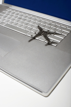 Shadow of jumbo jet over apple macintosh keyboardの写真素材