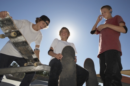 Three teenage boys (16-17) with skateboards outdoorsの写真素材