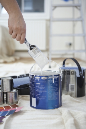 Man dipping paint brush into can close up of handの写真素材