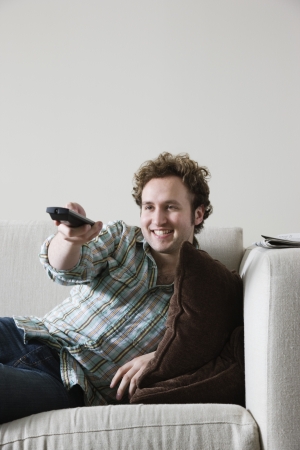 Man using remote control from sofaの写真素材