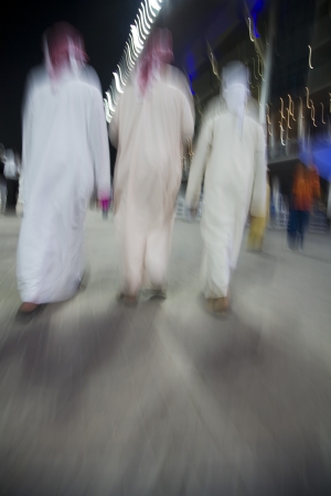 Dubai UAE small group of traditionally dressed Muslim men roaming grounds at Nad Al Shebaの写真素材