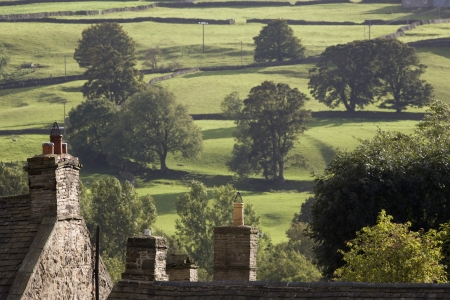 Roofs of houses and trees on fields in Yorkshire Dales Yorkshire Englandの写真素材