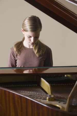 Girl (13-15) playing pianoの写真素材
