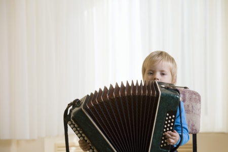 Boy (3-4) playing accordionの写真素材