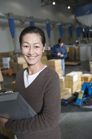 Asian woman in distribution warehouse portraitの写真素材