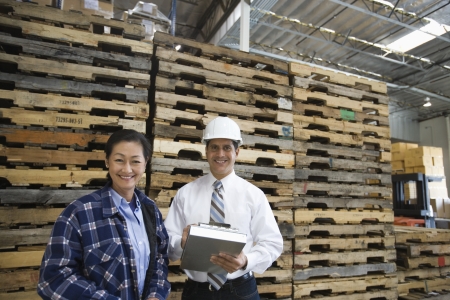 Woman and man standing in distribution warehouse portraitの写真素材