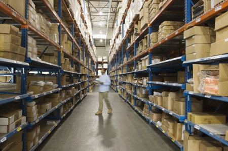 Man inspecting boxes in distribution warehouseの写真素材