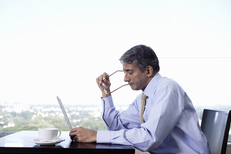 Business man sitting at table using laptopの写真素材
