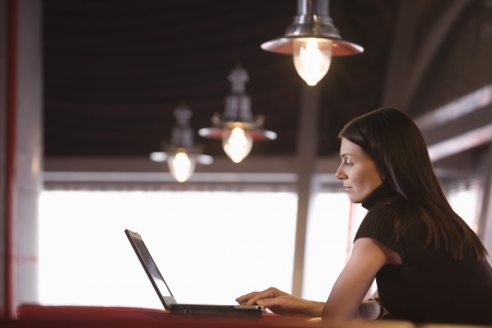 Young woman using laptop in cafeの写真素材