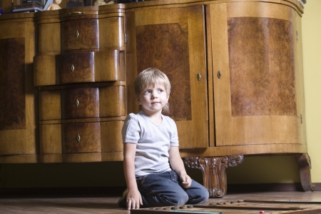 Boy playing wooden game on floorの写真素材